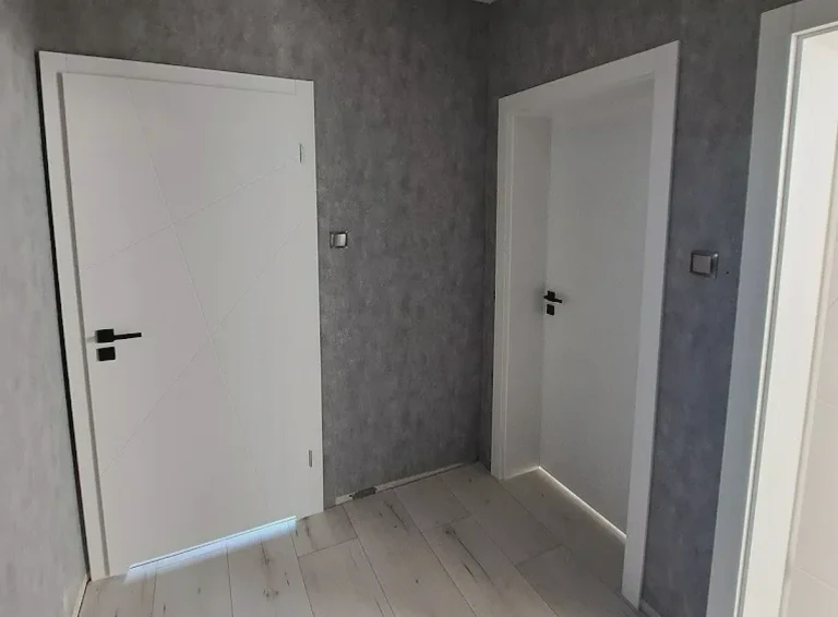 Białe drzwi w&nbsp;korytarzu